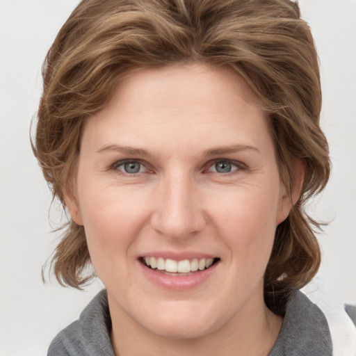 Joyful white young-adult female with medium  brown hair and blue eyes