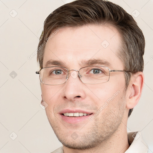 Joyful white adult male with short  brown hair and grey eyes