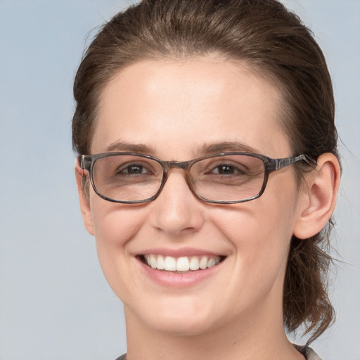 Joyful white young-adult female with medium  brown hair and grey eyes