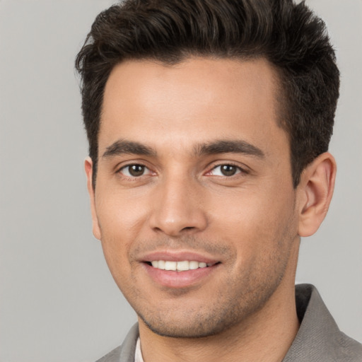 Joyful white young-adult male with short  brown hair and brown eyes