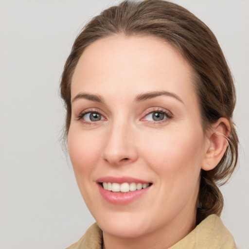 Joyful white young-adult female with medium  brown hair and green eyes