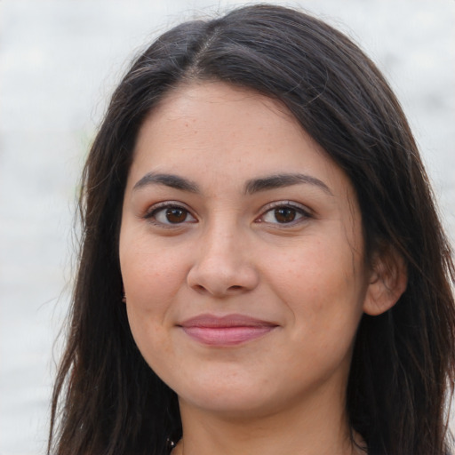 Joyful latino young-adult female with long  brown hair and brown eyes