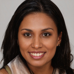 Joyful latino young-adult female with long  brown hair and brown eyes