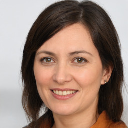 Joyful white adult female with medium  brown hair and brown eyes