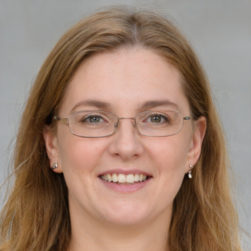 Joyful white adult female with long  brown hair and blue eyes