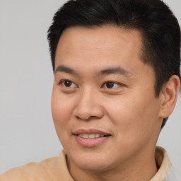 Joyful asian young-adult male with short  brown hair and brown eyes