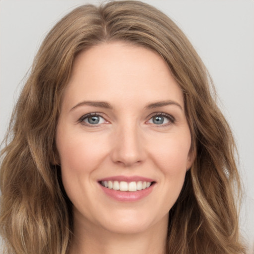 Joyful white young-adult female with long  brown hair and green eyes