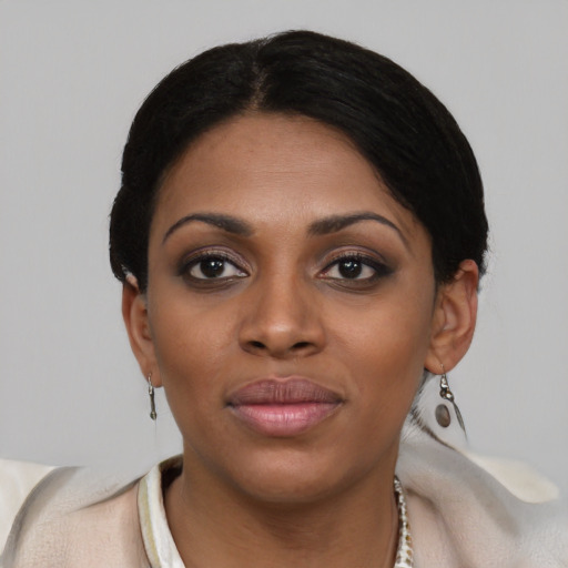 Joyful black young-adult female with short  black hair and brown eyes