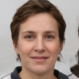 Joyful white adult female with medium  brown hair and grey eyes