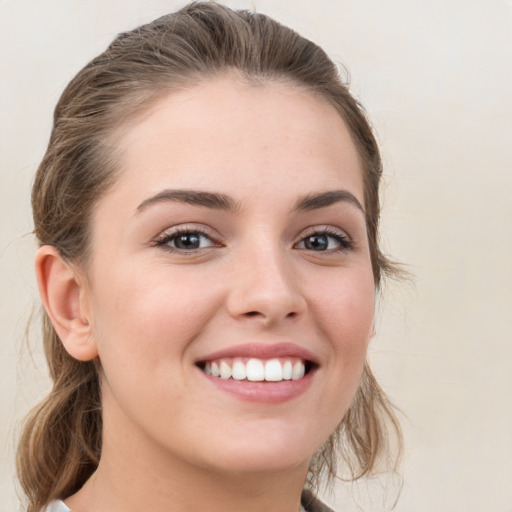 Joyful white young-adult female with medium  brown hair and grey eyes