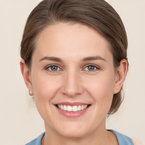 Joyful white young-adult female with medium  brown hair and grey eyes