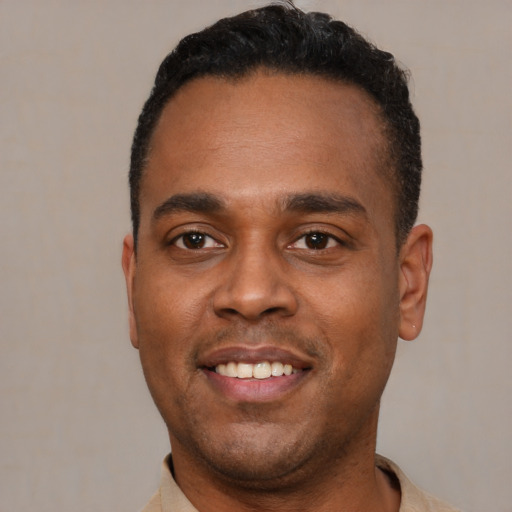 Joyful latino young-adult male with short  black hair and brown eyes