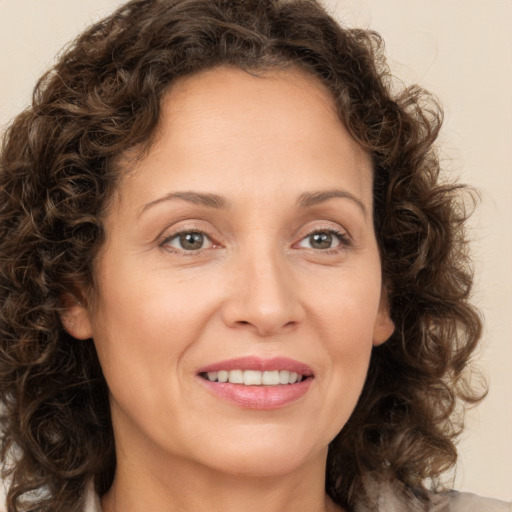 Joyful white adult female with medium  brown hair and green eyes