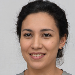 Joyful latino young-adult female with medium  brown hair and brown eyes