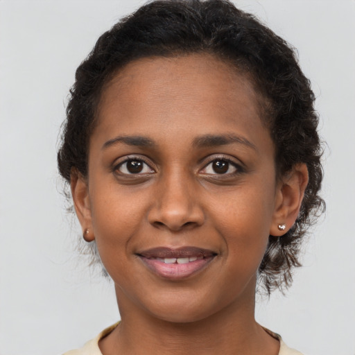 Joyful black young-adult female with short  brown hair and brown eyes