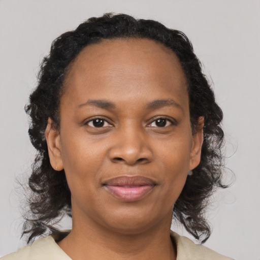 Joyful black young-adult female with medium  brown hair and brown eyes
