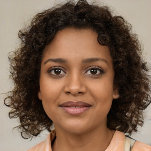 Joyful black young-adult female with medium  brown hair and brown eyes
