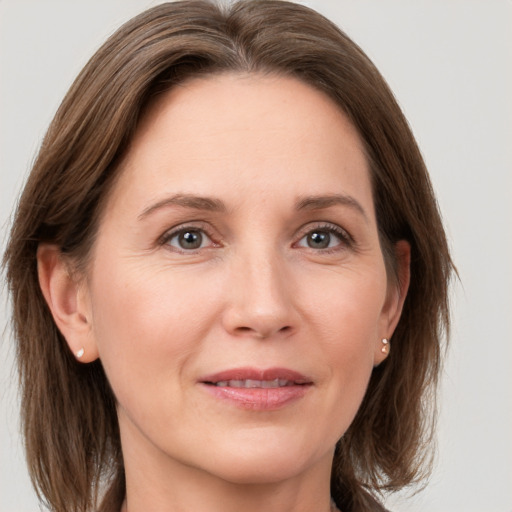 Joyful white adult female with medium  brown hair and grey eyes