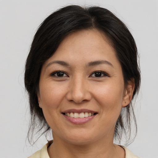 Joyful asian adult female with medium  brown hair and brown eyes