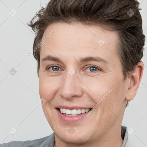 Joyful white adult male with short  brown hair and grey eyes