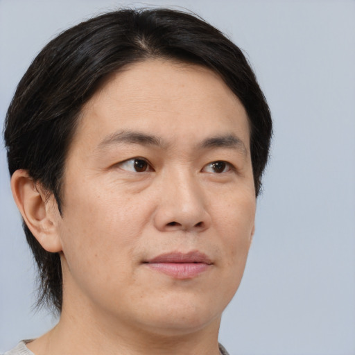 Joyful asian adult male with short  brown hair and brown eyes