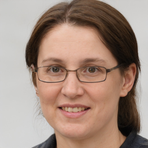 Joyful white adult female with medium  brown hair and grey eyes