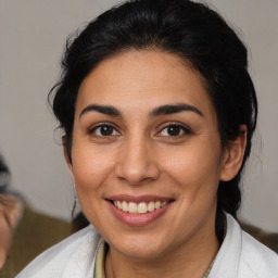 Joyful latino young-adult female with medium  brown hair and brown eyes