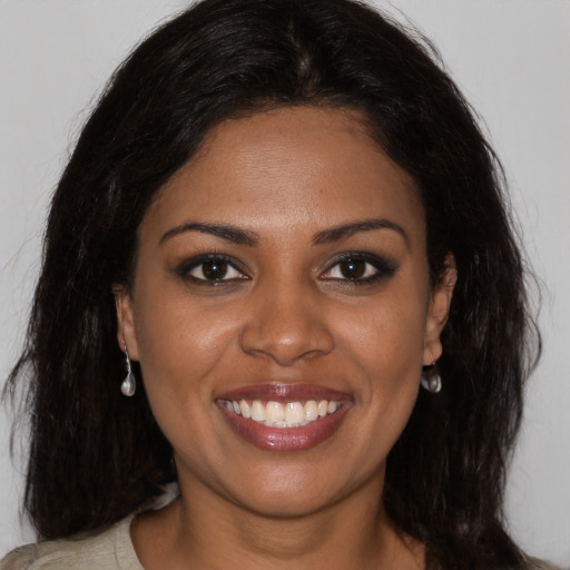 Joyful black young-adult female with long  brown hair and brown eyes