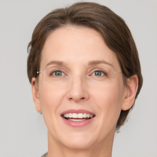 Joyful white adult female with medium  brown hair and grey eyes