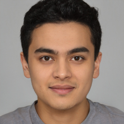 Joyful latino young-adult male with short  brown hair and brown eyes