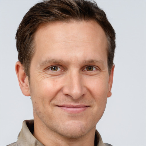 Joyful white adult male with short  brown hair and grey eyes