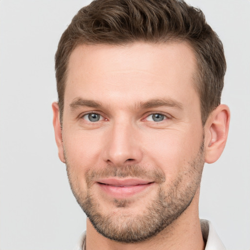 Joyful white young-adult male with short  brown hair and grey eyes