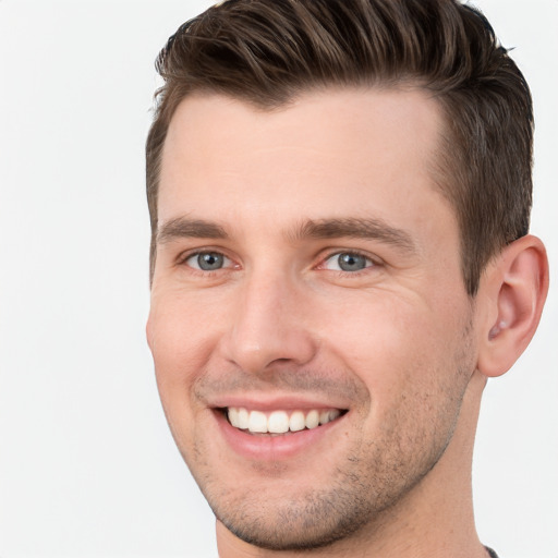 Joyful white young-adult male with short  brown hair and grey eyes