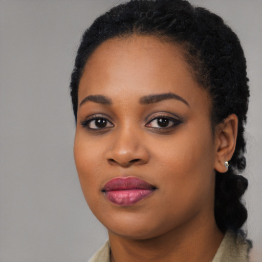 Joyful black young-adult female with long  black hair and brown eyes