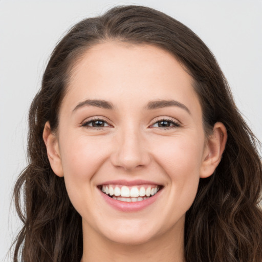 Joyful white young-adult female with long  brown hair and grey eyes