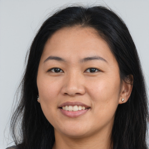Joyful asian young-adult female with long  brown hair and brown eyes