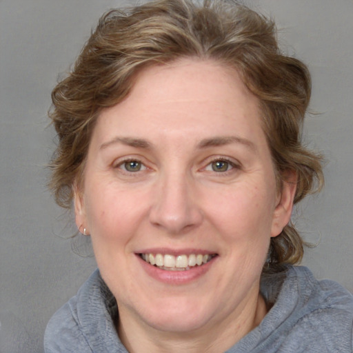 Joyful white adult female with medium  brown hair and blue eyes