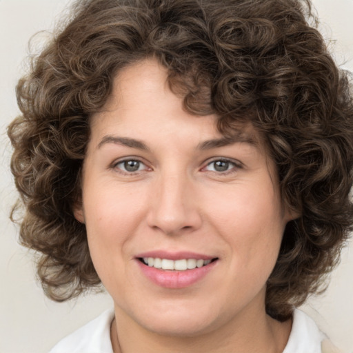 Joyful white young-adult female with medium  brown hair and green eyes