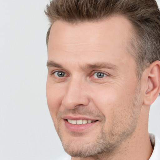 Joyful white adult male with short  brown hair and brown eyes