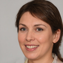 Joyful white adult female with medium  brown hair and grey eyes