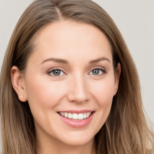 Joyful white young-adult female with long  brown hair and grey eyes