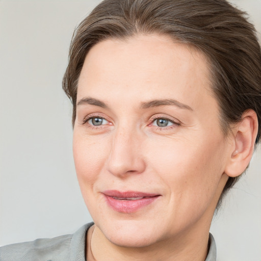 Joyful white adult female with medium  brown hair and grey eyes