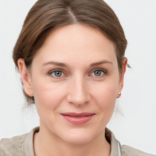 Joyful white young-adult female with medium  brown hair and grey eyes