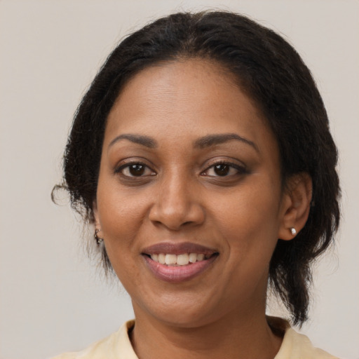 Joyful black adult female with medium  brown hair and brown eyes