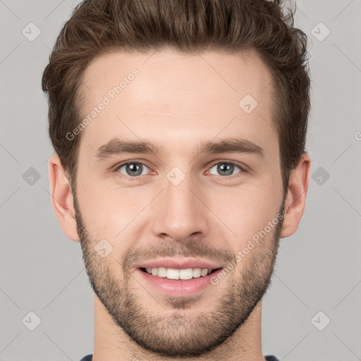 Joyful white young-adult male with short  brown hair and grey eyes