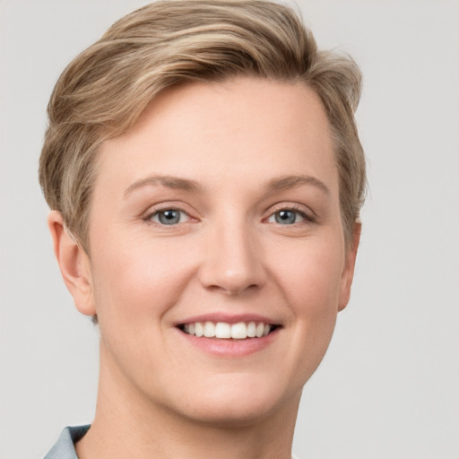 Joyful white young-adult female with short  brown hair and grey eyes