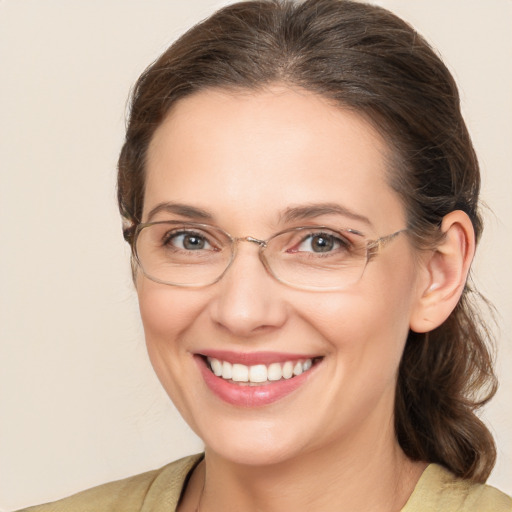 Joyful white adult female with medium  brown hair and grey eyes