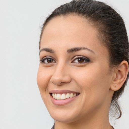 Joyful white young-adult female with long  brown hair and brown eyes