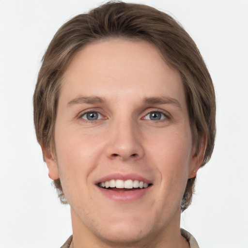 Joyful white young-adult male with short  brown hair and grey eyes