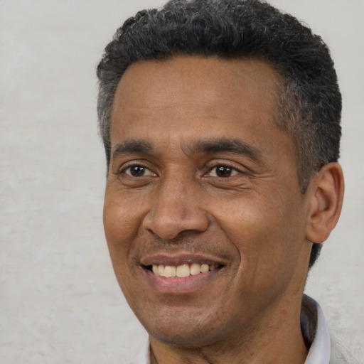 Joyful black adult male with short  black hair and brown eyes